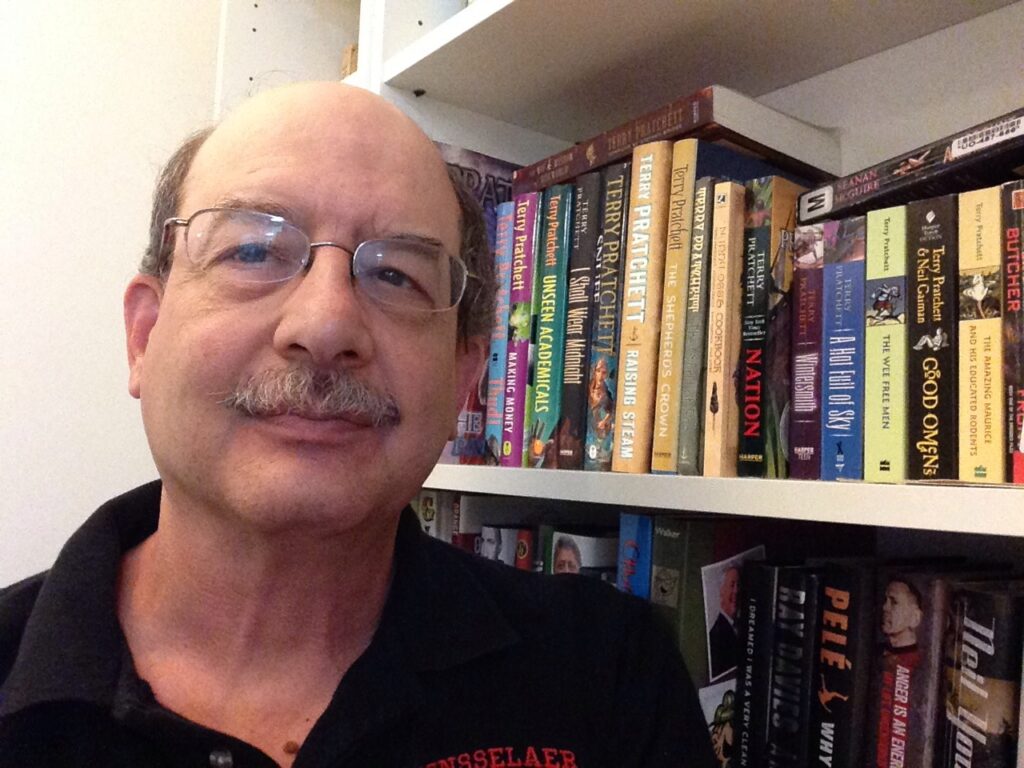 Dave in front of his bookshelf